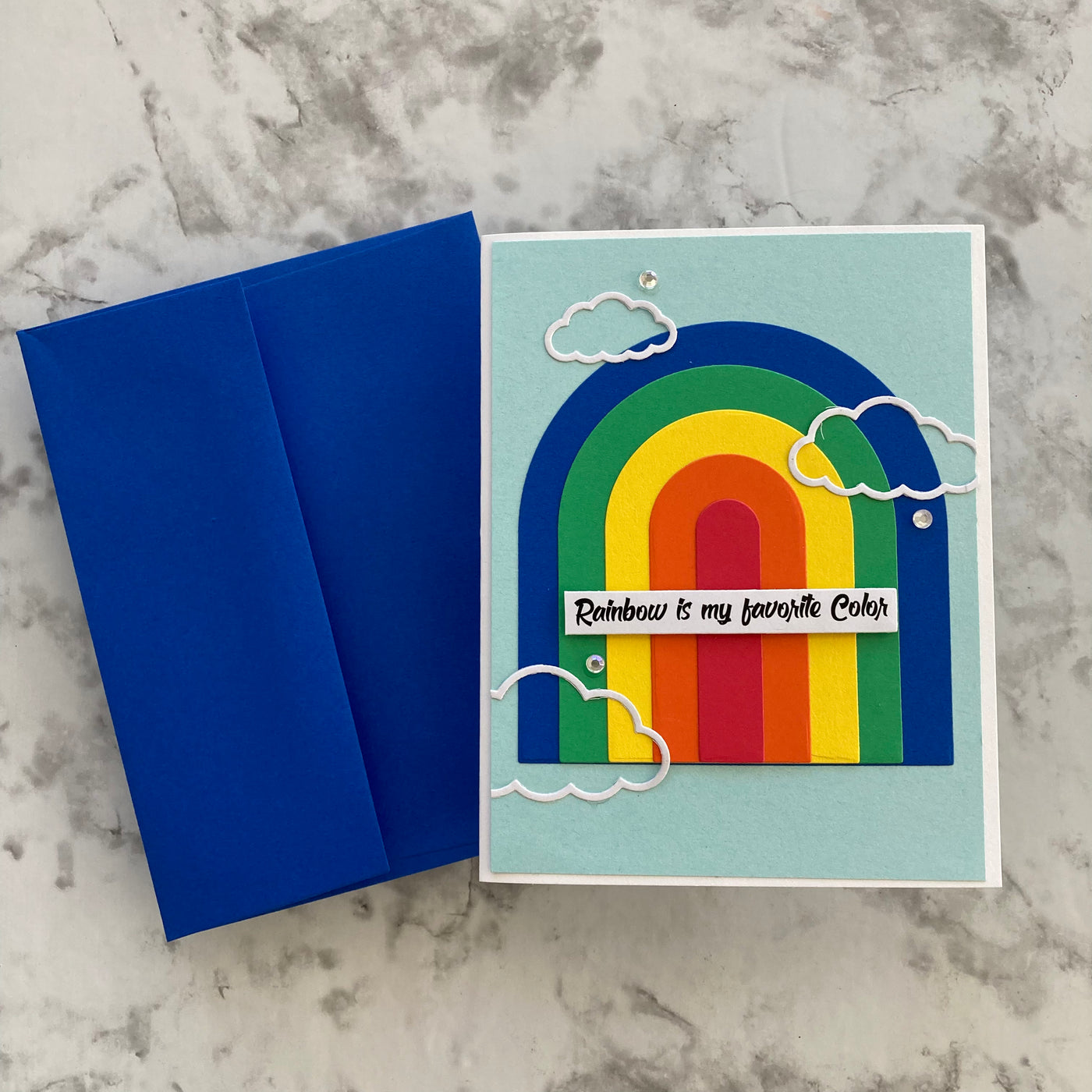 handmade rainbow card featuring a matching blue envelope