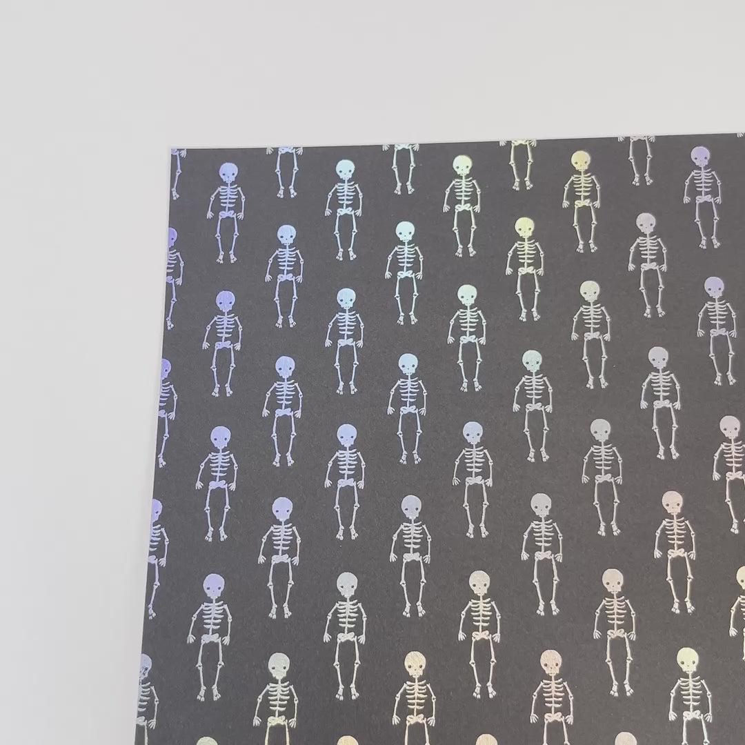 holographic silver foil skeletons on a black cardstock background